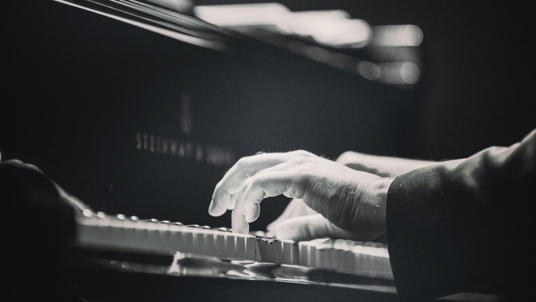 Close-up of hands playing a felt piano